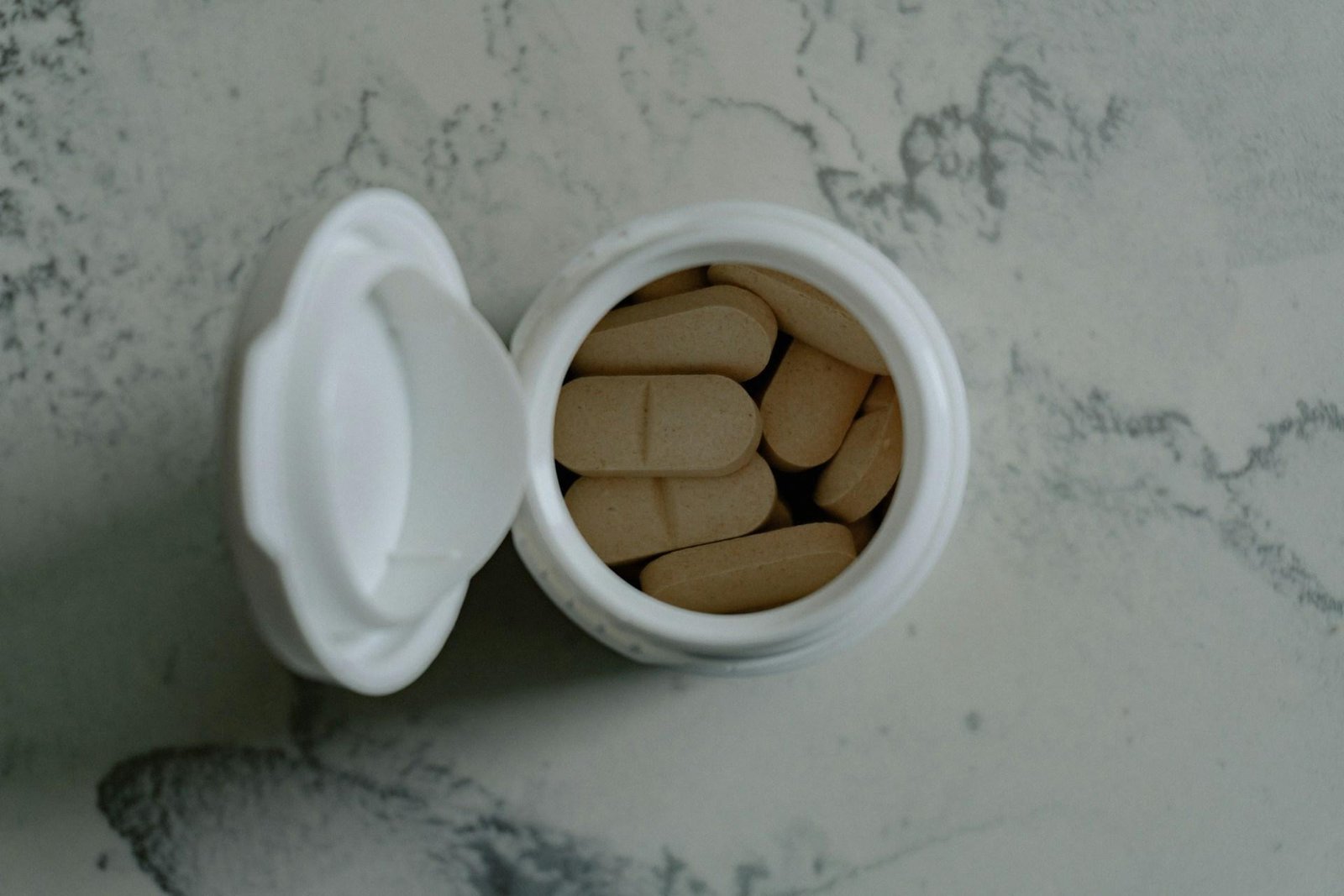 Open container of supplement tablets representing convenient daily wellness support