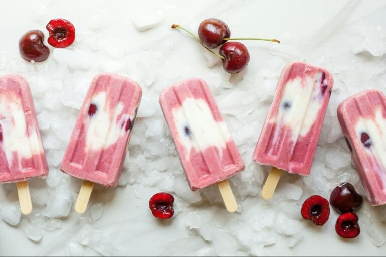 Homemade cherry yogurt popsicles arranged on ice, showcasing simple DIY frozen treats made with fresh ingredients If you want it more indulgent, more health-focused, or more minimalist/editorial, I can adjust the wording quickly.
