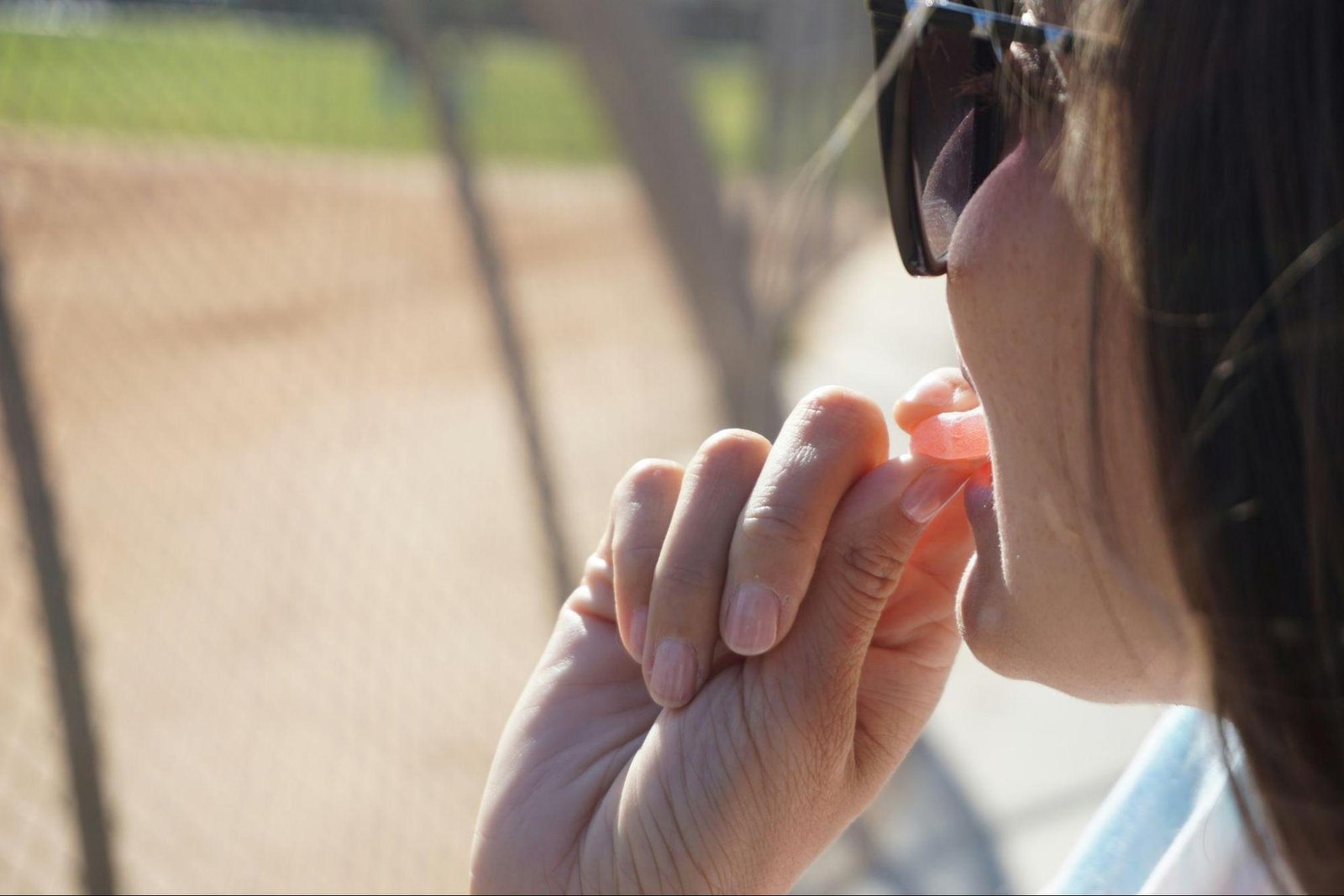 Person holding a small gummy outdoors, illustrating a measured and intentional approach to relaxation in everyday life
