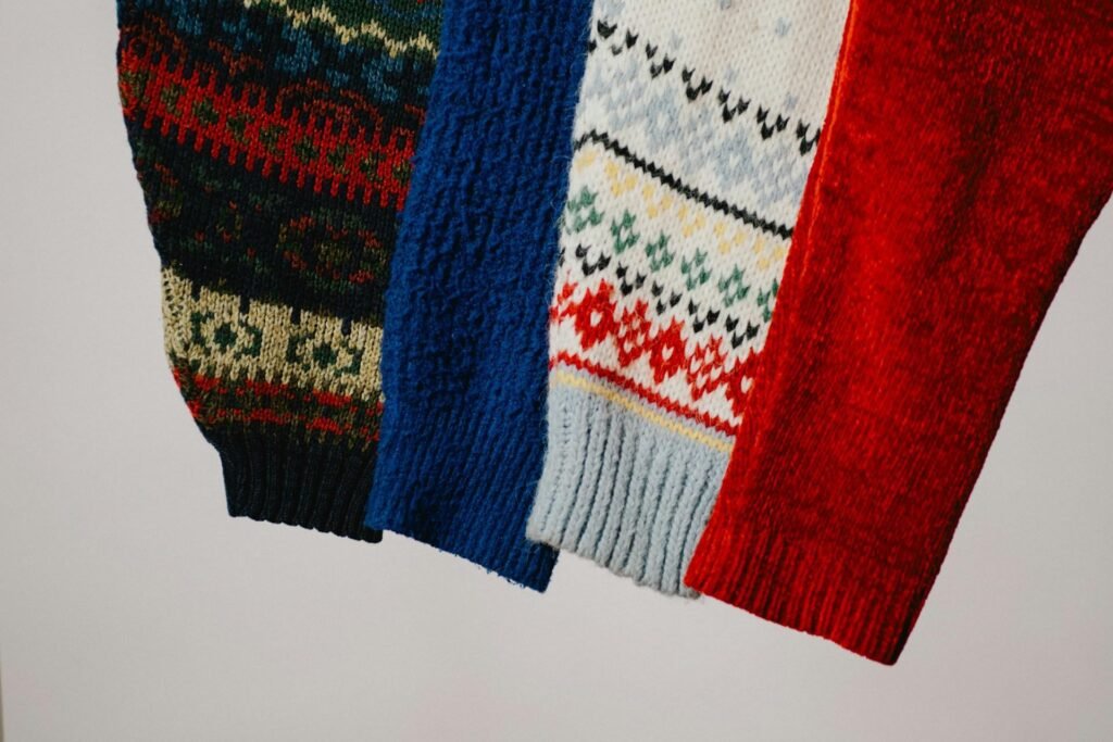 Close-up of multiple heritage knit sweaters showing classic patterns, textures, and wool craftsmanship