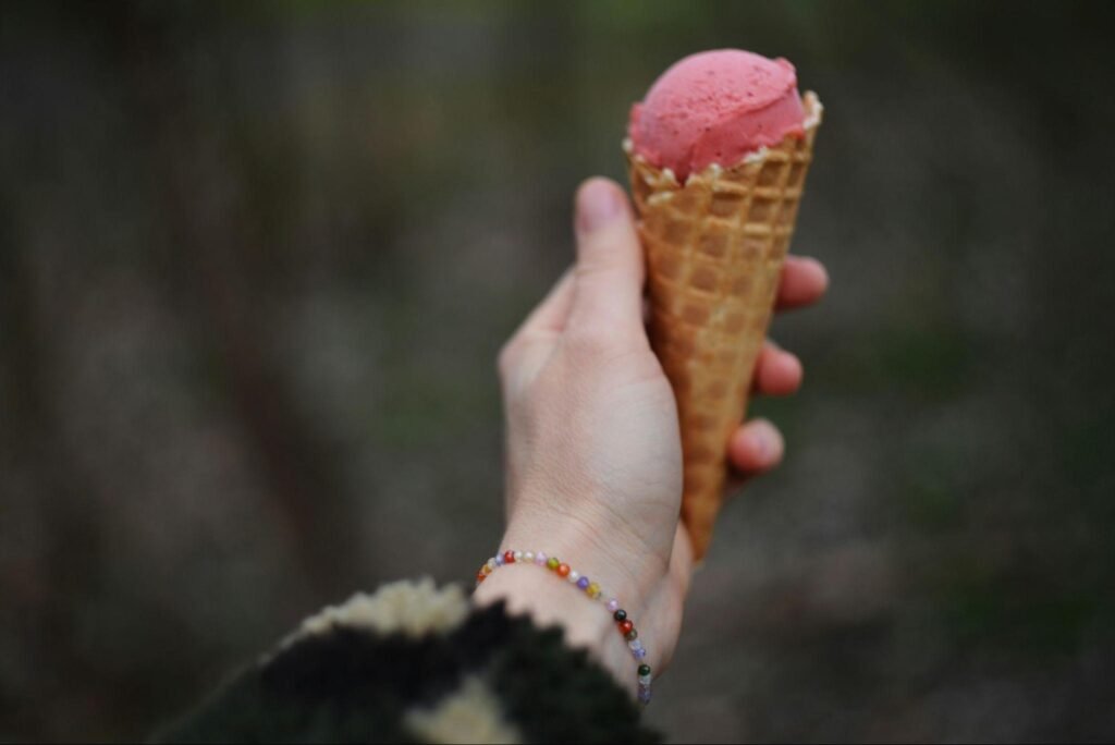 Hand holding a cone of homemade berry ice cream, highlighting simple DIY frozen desserts enjoyed in daily life If you want it more lifestyle-driven, more food-focused, or more minimalist, I can tweak it instantly.